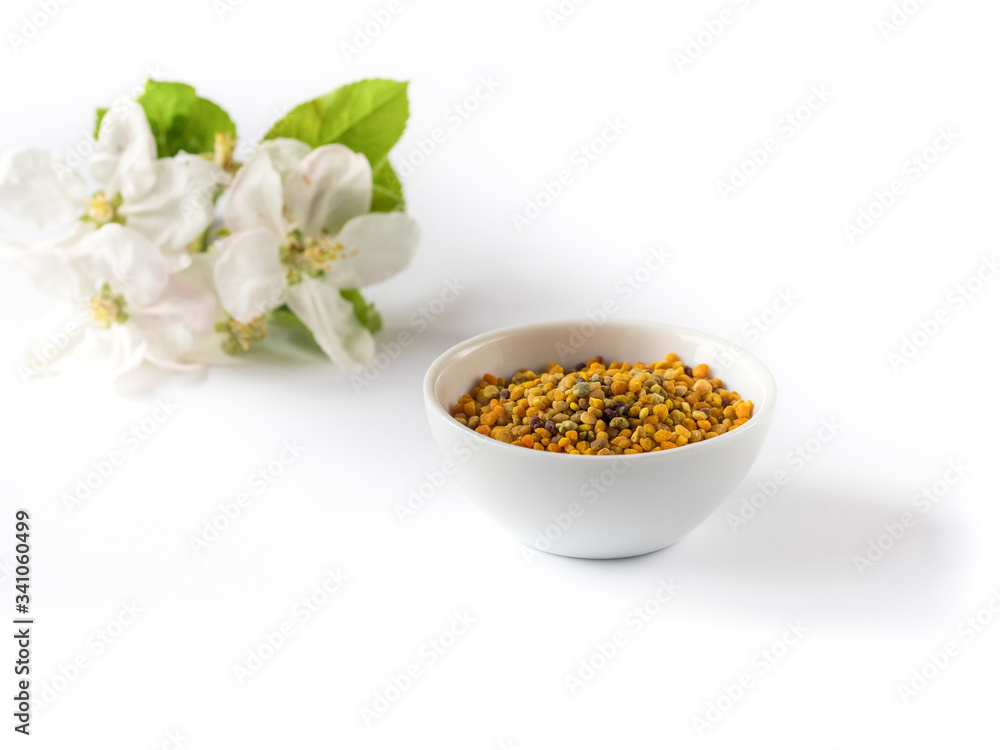 Bee pollen grains in white ceramic bowl and honeycombs isolated Bee pollen grains in white ceramic bowl and honeycombs isolated