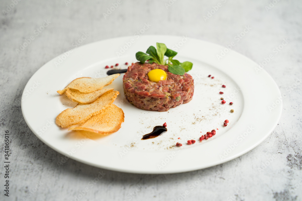 Raw beef tartare served with thin crispy croutons and balsamic sauce Raw beef tartare served with thin crispy croutons and balsamic sauce