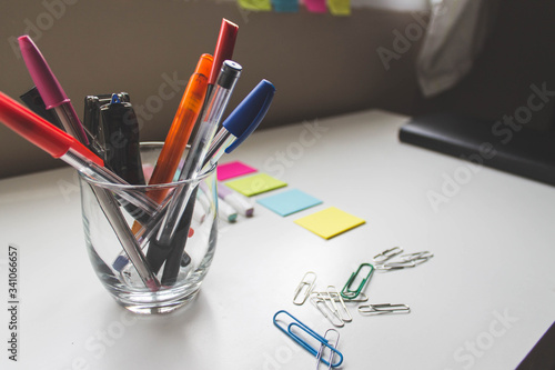Oficina con rotulador, bolígrafo, notas, clips, libreta en un escritorio photo