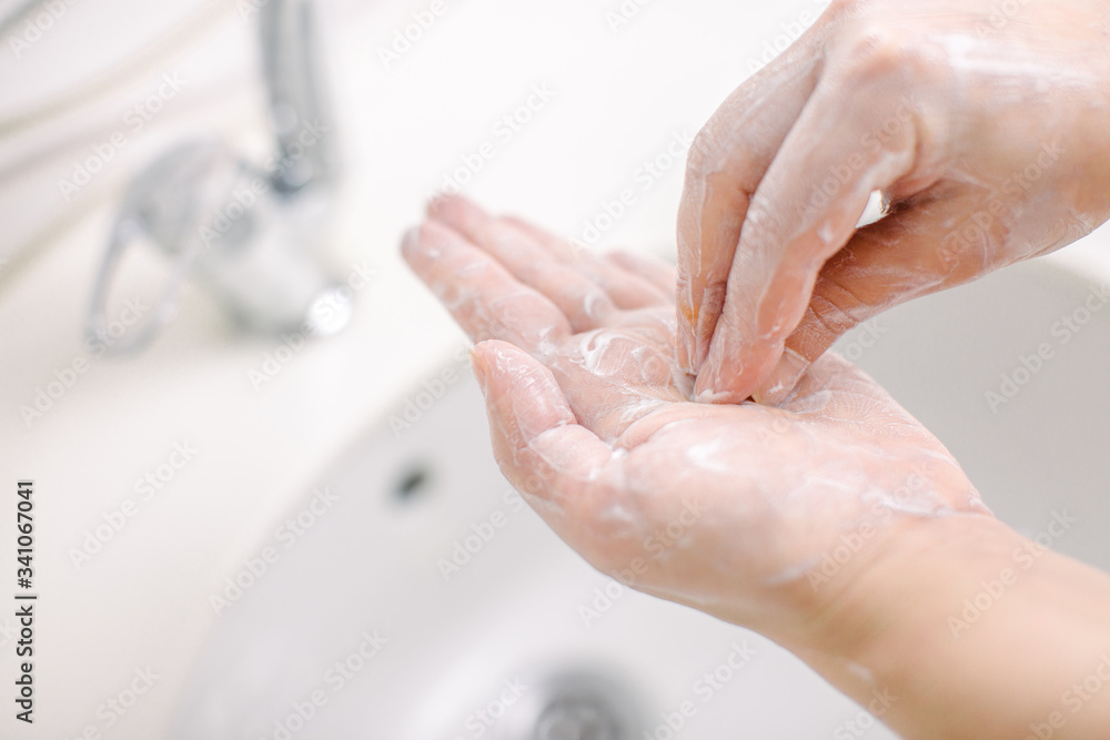 Woman washes her hands by surgical hand washing method. She washes his hands for at least 20 seconds. She washes the palm of his hand. Woman washes her hands by surgical hand washing method. She washes his hands for at least 20 seconds. She washes the palm of his hand.