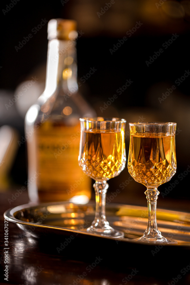 Bourbon in glasses on the bar with a bottle in the background Bourbon in glasses on the bar with a bottle in the background