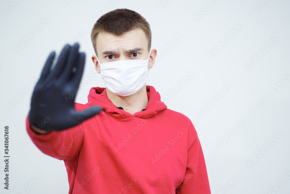 Stop spreading of COVID-19. Man with mask and gloves showing stop symbol. Pandemic worldwide problem. Symbol of protection and responsability. Stop spreading of COVID-19. Man with mask and gloves showing stop symbol. Pandemic worldwide problem. Symbol of protection and responsability.