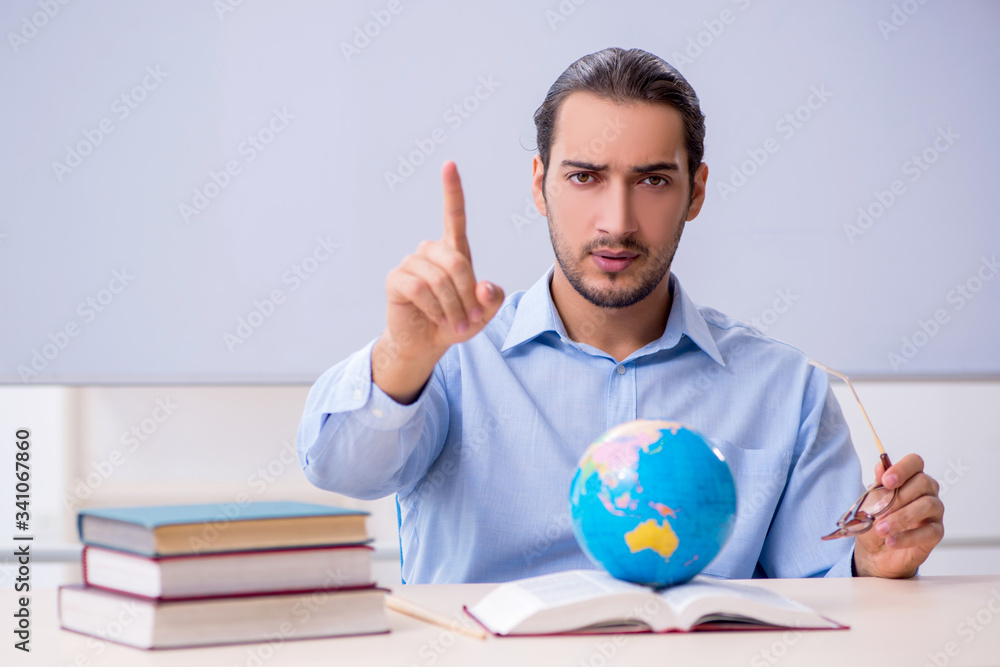 Young male geography teacher in front of whiteboard Young male geography teacher in front of whiteboard