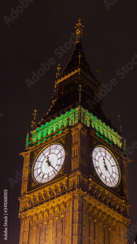 Ansicht von unten auf die Uhr des Big Ben in London, England bei Nacht