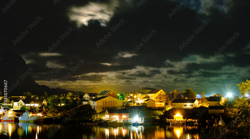 Fototapeta premium view of the Reine village at night, Lofoten islands, Rorbu in the light of lanterns