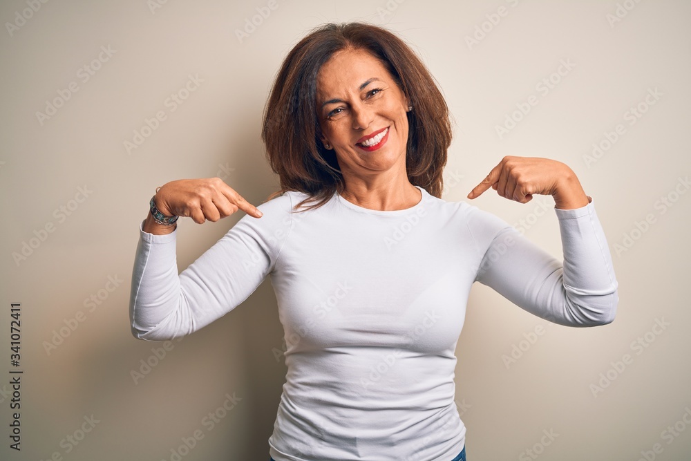 Middle age beautiful woman wearing casual t-shirt standing over isolated white background looking confident with smile on face, pointing oneself with fingers proud and happy. Middle age beautiful woman wearing casual t-shirt standing over isolated white background looking confident with smile on face, pointing oneself with fingers proud and happy.