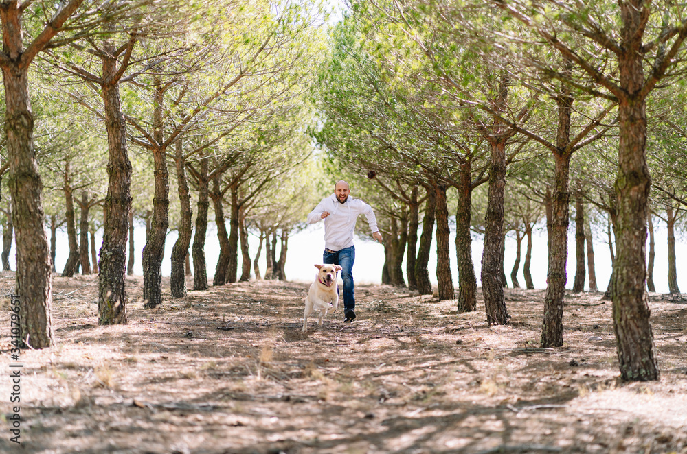 Man running with his dog in a park Man running with his dog in a park