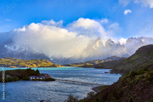 Chile, Ultima Esperanza Province, Lodge on small island of Lake Pehoe with Cuernos del Paine shrouded in clouds in background photo