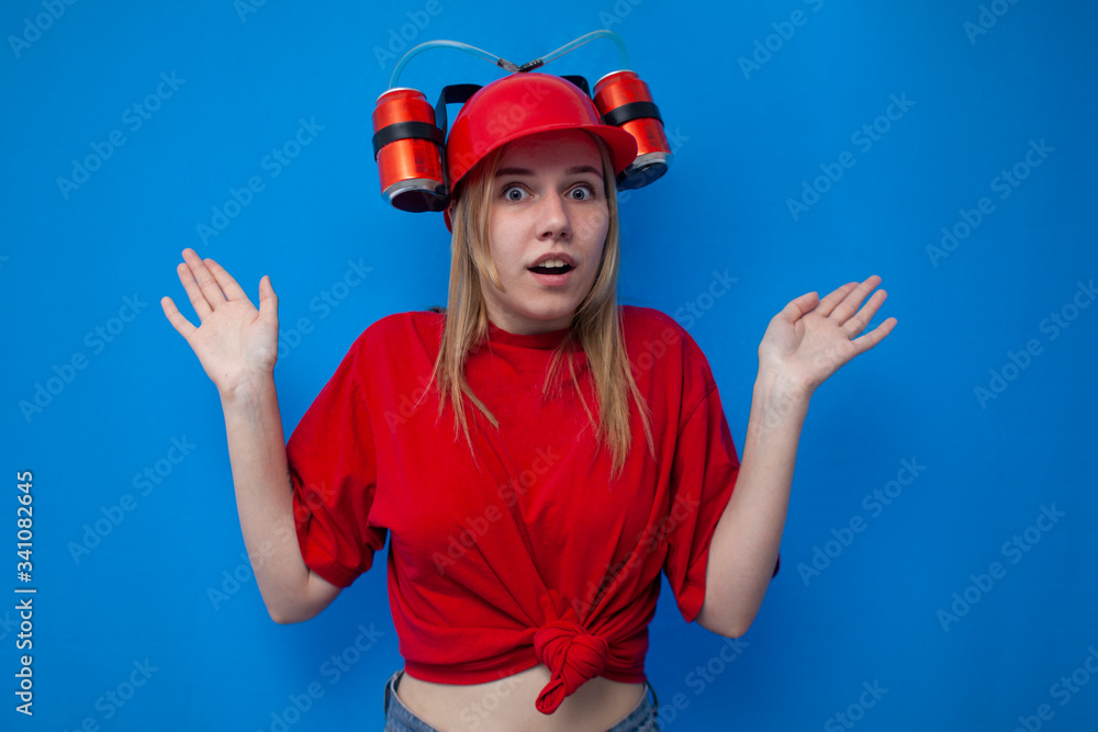 surprised funny girl fan in red clothes and with a beer hat on a blue background shrugs, fan shrugs surprised funny girl fan in red clothes and with a beer hat on a blue background shrugs, fan shrugs