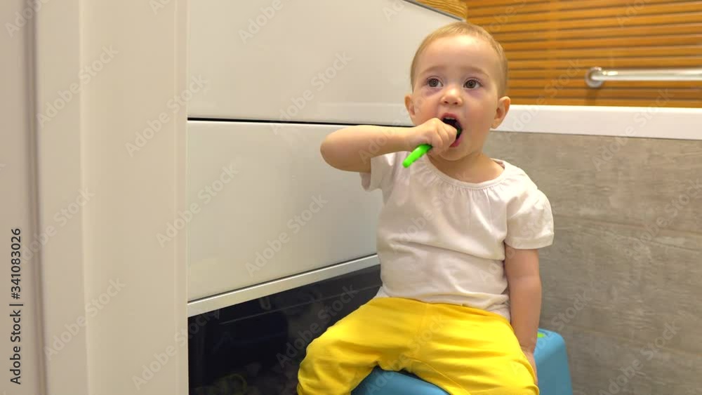 Little girl brushing her first teeth. A one year old baby brushes her teeth. Little girl brushing her first teeth. A one year old baby brushes her teeth.