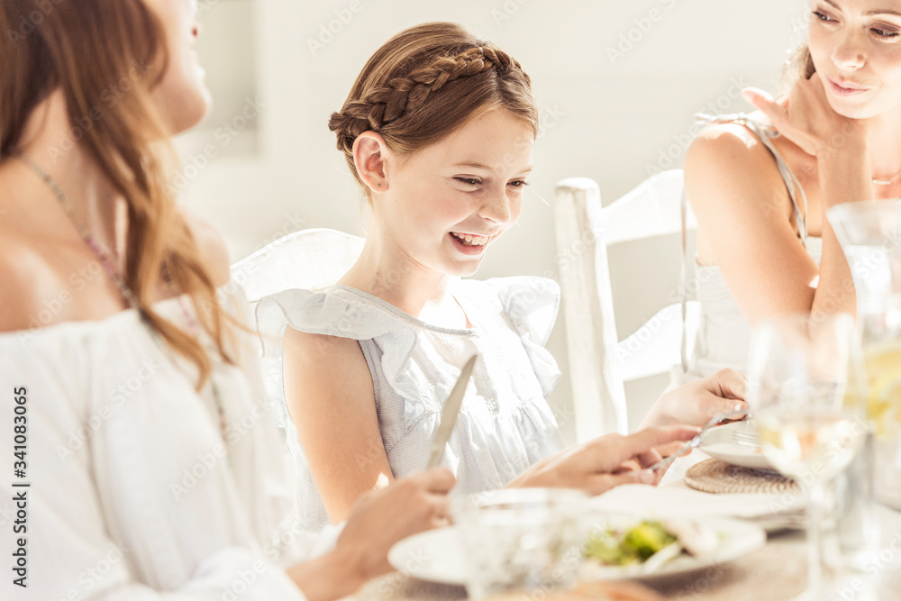 Happy girl and two women having lunch together Happy girl and two women having lunch together
