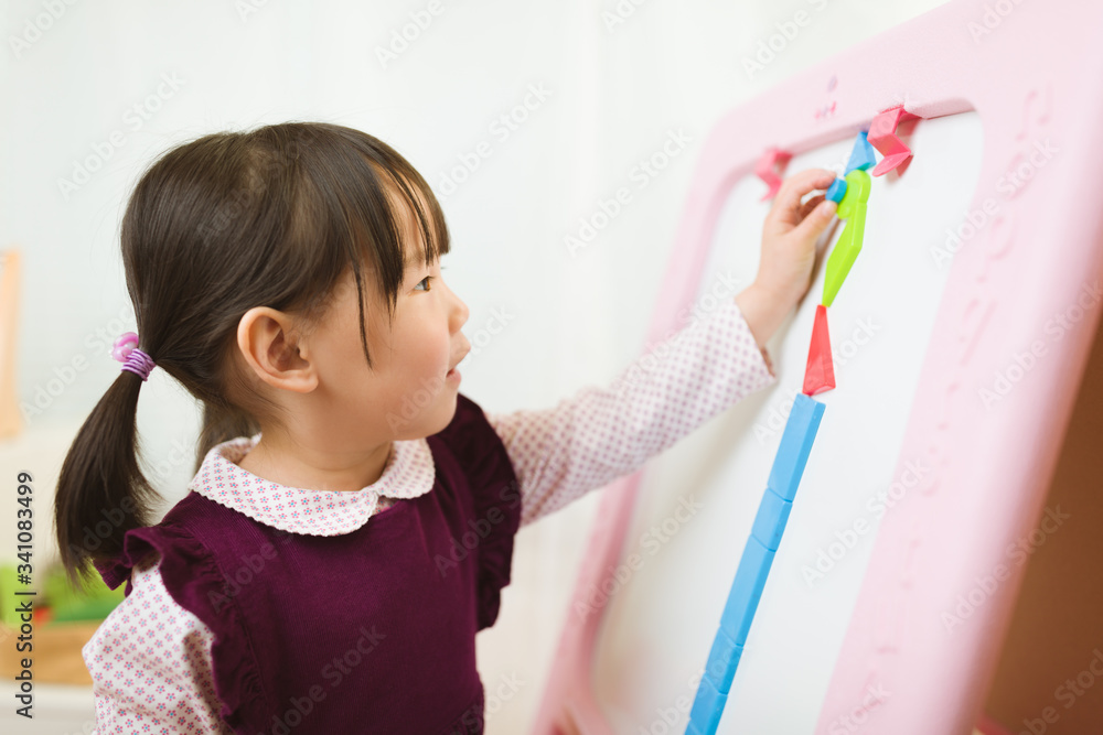 toddler girl playing creative shape blocks at home against white background toddler girl playing creative shape blocks at home against white background