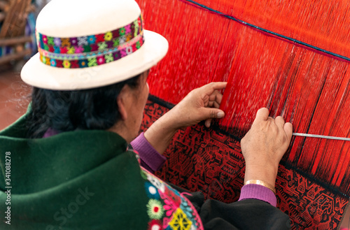 Φωτογραφία Indigenous Woman in traditional clothes weaving a colorful Jalq'a fabric in Sucre, Bolivia