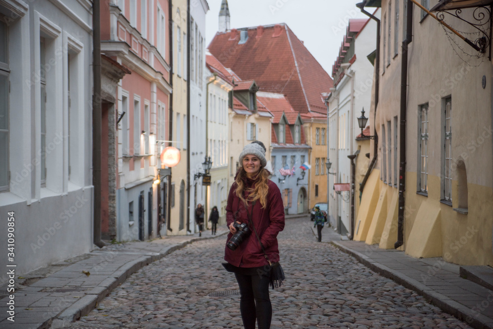 cute female photographer walking down the old streets of telling estonia