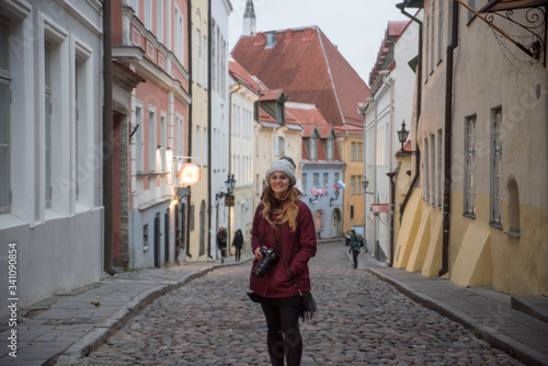 cute female photographer walking down the old streets of telling estonia © Zach