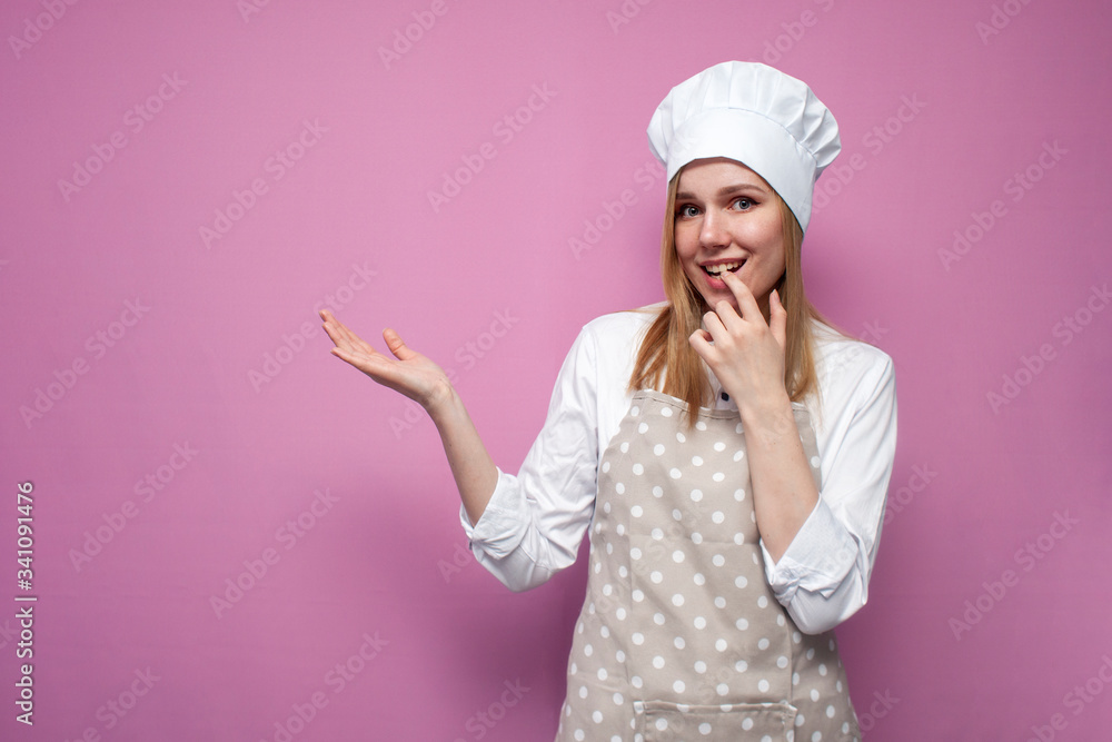 portrait of a young cheerful girl cooks in kitchen clothes on a colored background, woman housewife smiles portrait of a young cheerful girl cooks in kitchen clothes on a colored background, woman housewife smiles
