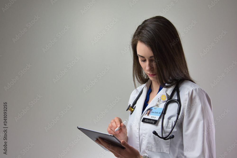 woman making note on tablet for patient care in hospital. Healthcare female, could be MD, PA, or NP woman making note on tablet for patient care in hospital. Healthcare female, could be MD, PA, or NP