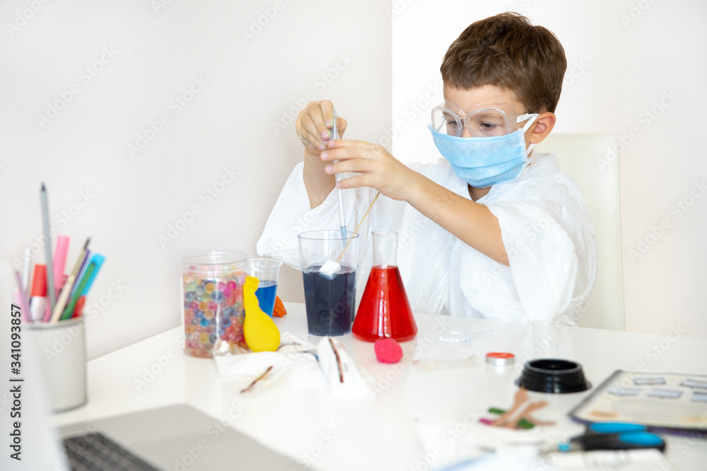Little boy in protective uniform and mask studing at home Little boy in protective uniform and mask studing at home