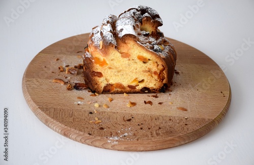 Kraffin Easter cake in powdered sugar with raisins, dried apricots and nuts on wooden cutting board
