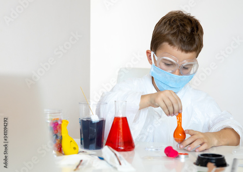 Young man using baloons for chemistry experiments