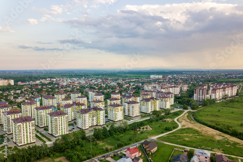 Fototapeta Naklejka Na Ścianę i Meble -  Top view of urban developing city landscape with tall apartment buildings and suburb houses. Drone aerial photography.