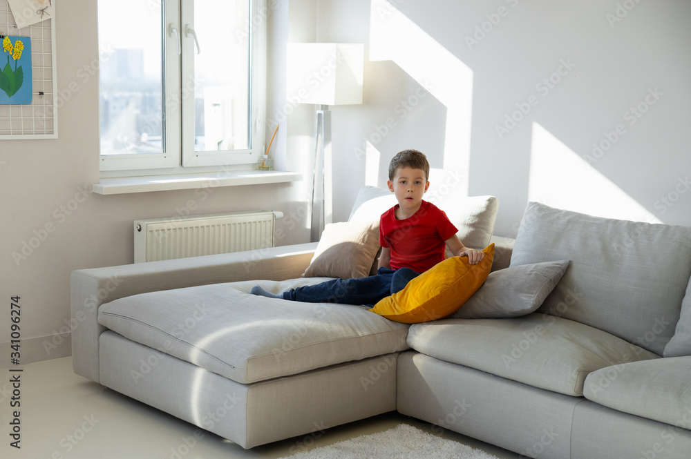 Bored little kid staying in cozy apartment Bored little kid staying in cozy apartment