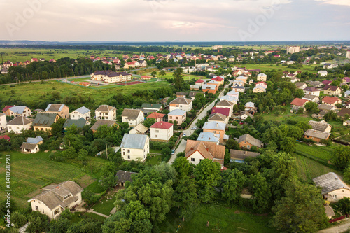 Aerial landscape of small town or village with rows of residential homes and green trees.