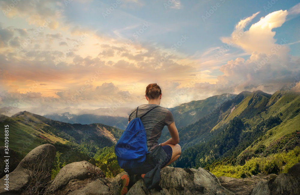 Naklejka premium Sporty hiking girl enjoying beautiful mountain view. Back photo of female hiker resting.