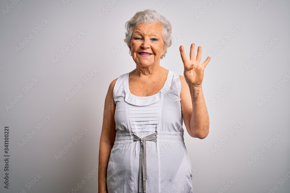 Senior beautiful grey-haired woman wearing casual summer dress over white background showing and pointing up with fingers number four while smiling confident and happy. Senior beautiful grey-haired woman wearing casual summer dress over white background showing and pointing up with fingers number four while smiling confident and happy.