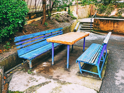 A homemade table and two benches outside to play dominoes