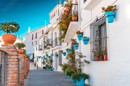 Obraz na plátně Beautiful view of old Mijas Calle Moro, white houses and aqua blue flower pots