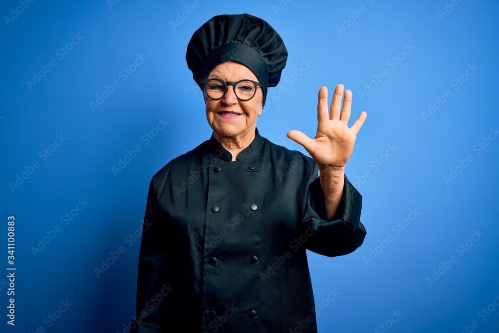 Senior beautiful grey-haired chef woman wearing cooker uniform and hat over blue background showing and pointing up with fingers number five while smiling confident and happy. Senior beautiful grey-haired chef woman wearing cooker uniform and hat over blue background showing and pointing up with fingers number five while smiling confident and happy.