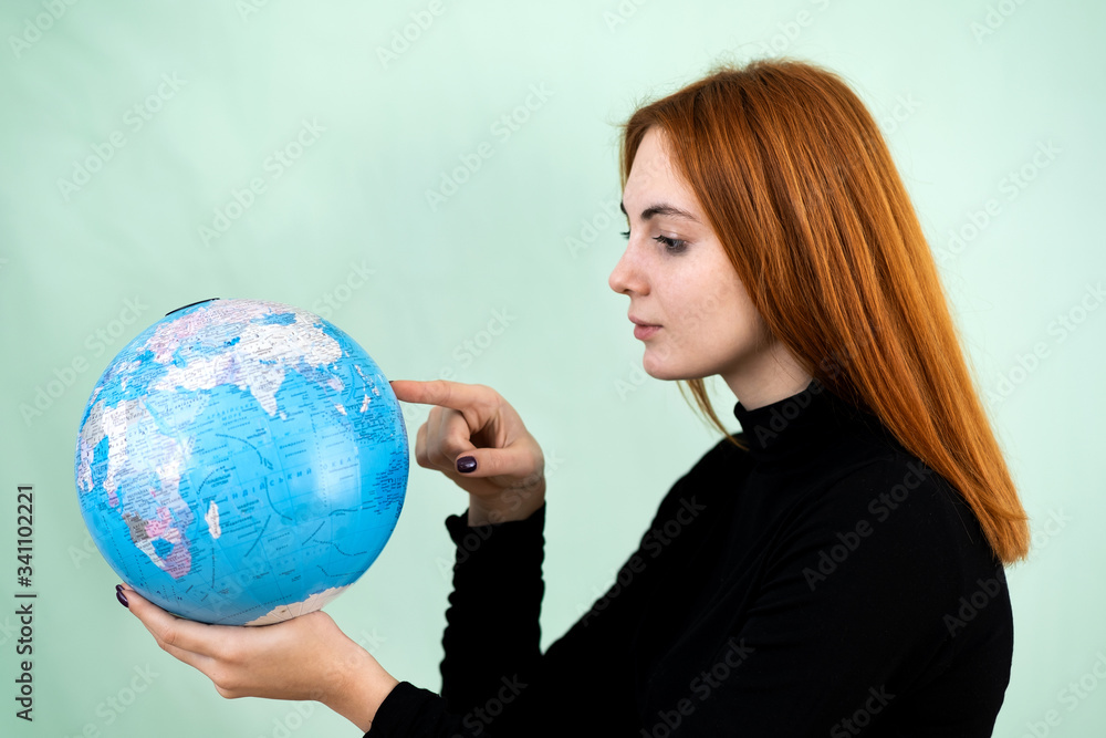 Portrait of a happy young woman holding geographic globe of the world in her hands. Travel destination and planet protection concept. Portrait of a happy young woman holding geographic globe of the world in her hands. Travel destination and planet protection concept.
