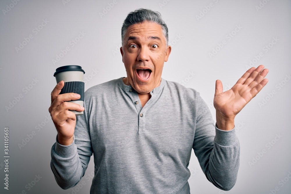 Middle age handsome grey-haired man drinking cup of coffee over isolated white background very happy and excited, winner expression celebrating victory screaming with big smile and raised hands Middle age handsome grey-haired man drinking cup of coffee over isolated white background very happy and excited, winner expression celebrating victory screaming with big smile and raised hands
