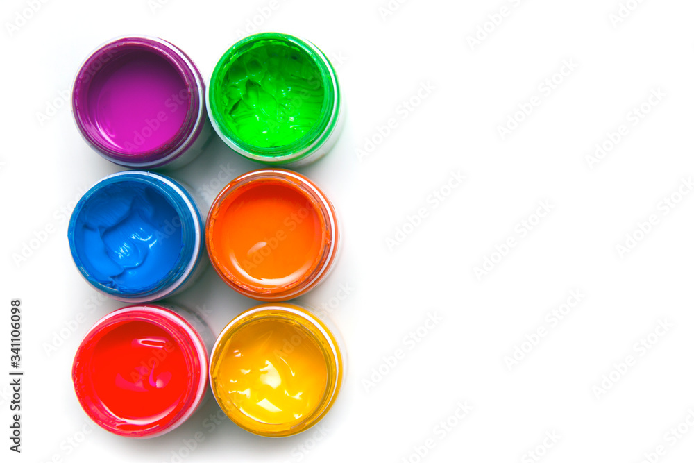 Jars with colored paint on a white background. Close-up, top view Jars with colored paint on a white background. Close-up, top view