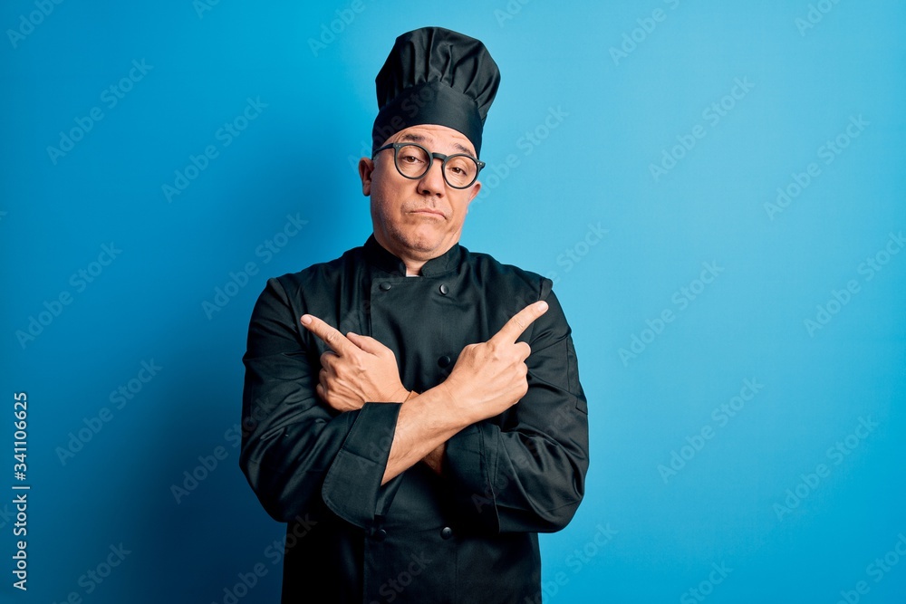 Middle age handsome grey-haired chef man wearing cooker uniform and hat Pointing to both sides with fingers, different direction disagree Middle age handsome grey-haired chef man wearing cooker uniform and hat Pointing to both sides with fingers, different direction disagree
