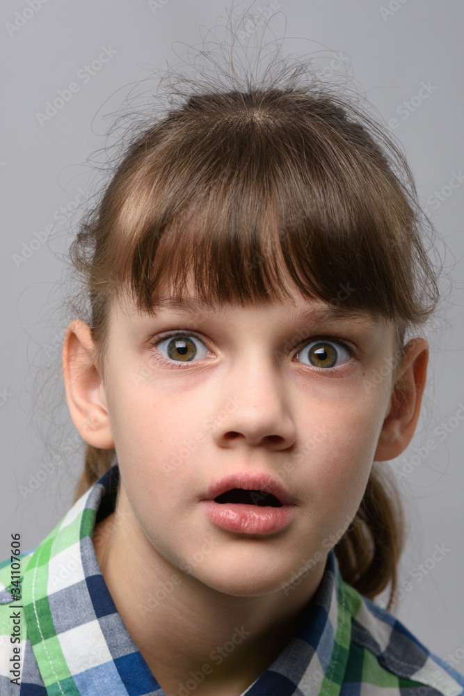 Portrait of a very surprised ten year old girl with bulging eyes and open mouth, European appearance, close-up Portrait of a very surprised ten year old girl with bulging eyes and open mouth, European appearance, close-up