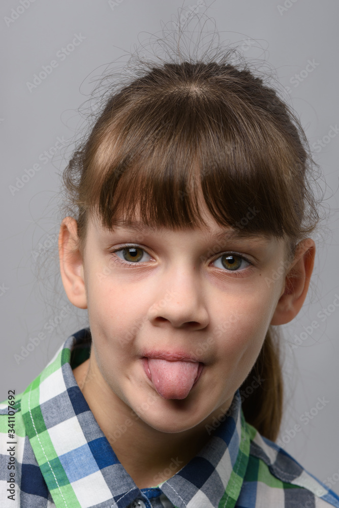 Portrait of a ten-year-old girl showing tongue, European appearance, close-up Portrait of a ten-year-old girl showing tongue, European appearance, close-up