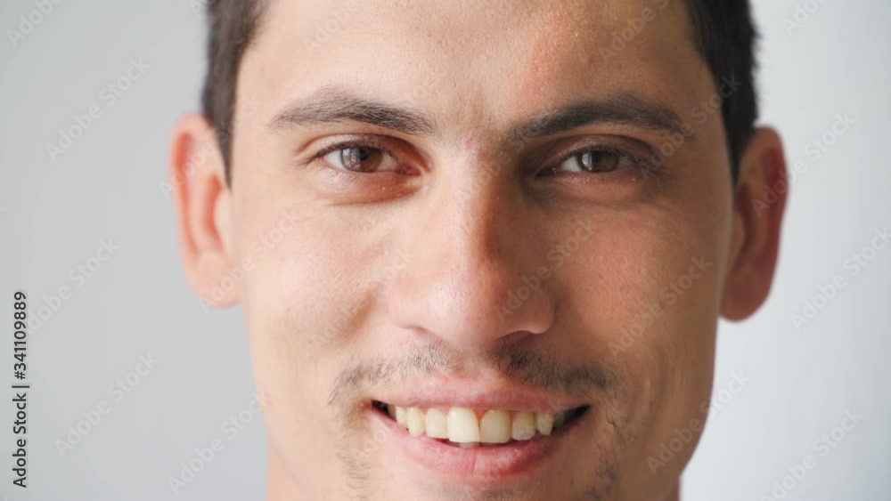 portrait Beautiful Caucasian young man smiling at the camera. Happy men's emotions on a white background. Slow motion portrait Beautiful Caucasian young man smiling at the camera. Happy men's emotions on a white background. Slow motion