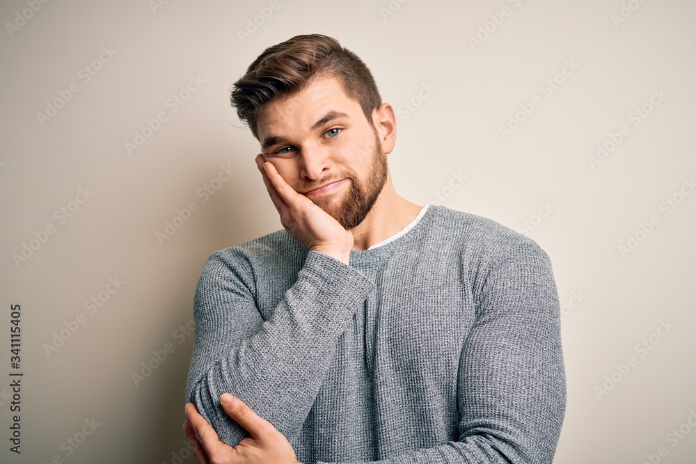 Young handsome blond man with beard and blue eyes wearing casual sweater thinking looking tired and bored with depression problems with crossed arms.