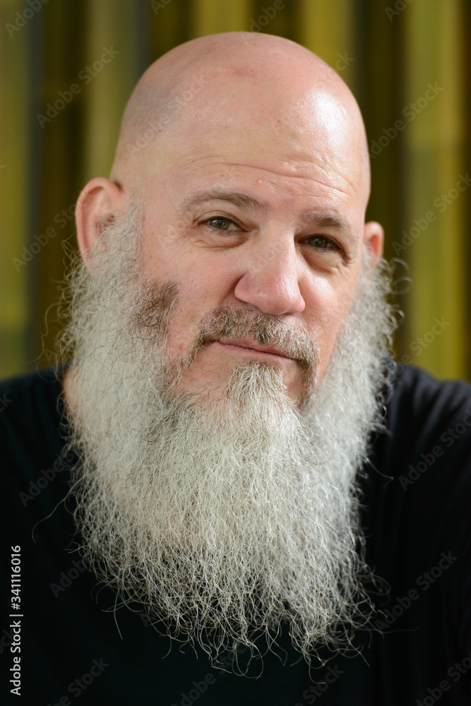 Face of mature handsome bald man with long beard outdoors Face of mature handsome bald man with long beard outdoors