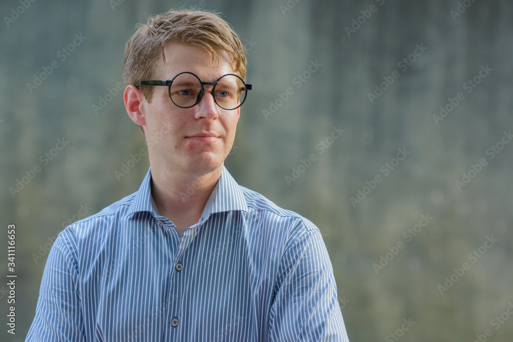 Face of young handsome blond businessman in the streets outdoors Face of young handsome blond businessman in the streets outdoors