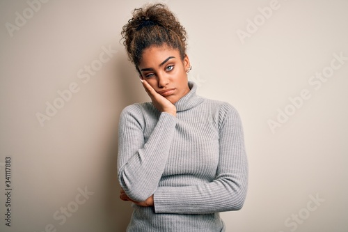 Beautiful african american girl wearing turtleneck sweater standing over white background thinking looking tired and bored with depression problems with crossed arms. © Krakenimages.com