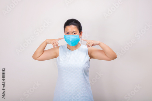 An Asian girl in blue tank top wears blue mask