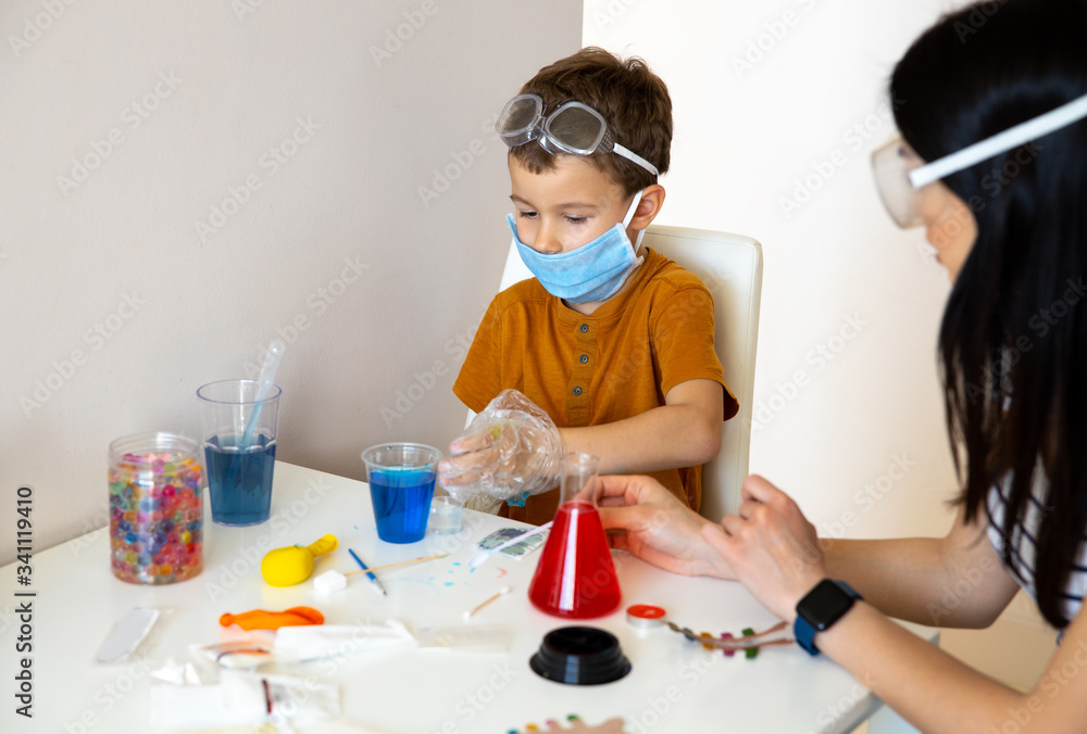 Concentrated little boy playing at home laboratory Concentrated little boy playing at home laboratory