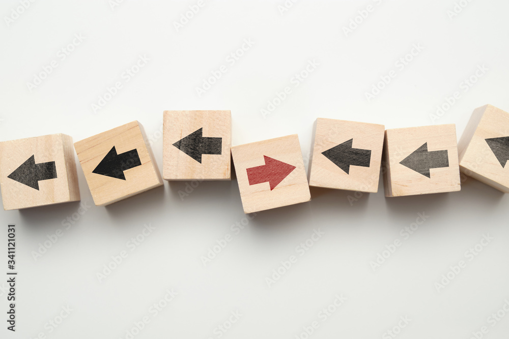 Obraz premium Concept of think differently - wooden cubes with arrows.