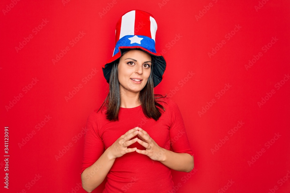 Young beautiful brunette woman wearing united states hat celebrating independence day Hands together and fingers crossed smiling relaxed and cheerful. Success and optimistic Young beautiful brunette woman wearing united states hat celebrating independence day Hands together and fingers crossed smiling relaxed and cheerful. Success and optimistic