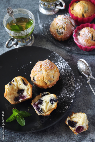 Blueberry muffins and tea on dark background