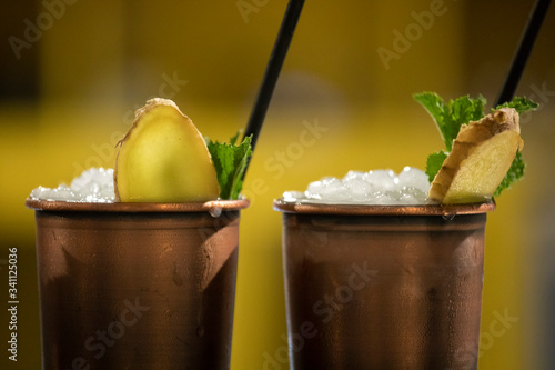 Photography two moscow mule cocktails with vodka, ginger beer, lime juice and ice with a yel