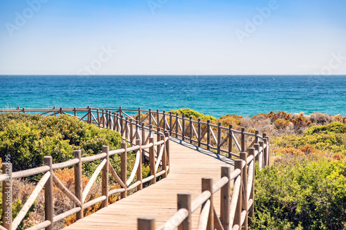 Cabopino beach, Marbella, Malaga. Wooden walkway to the beach. photo